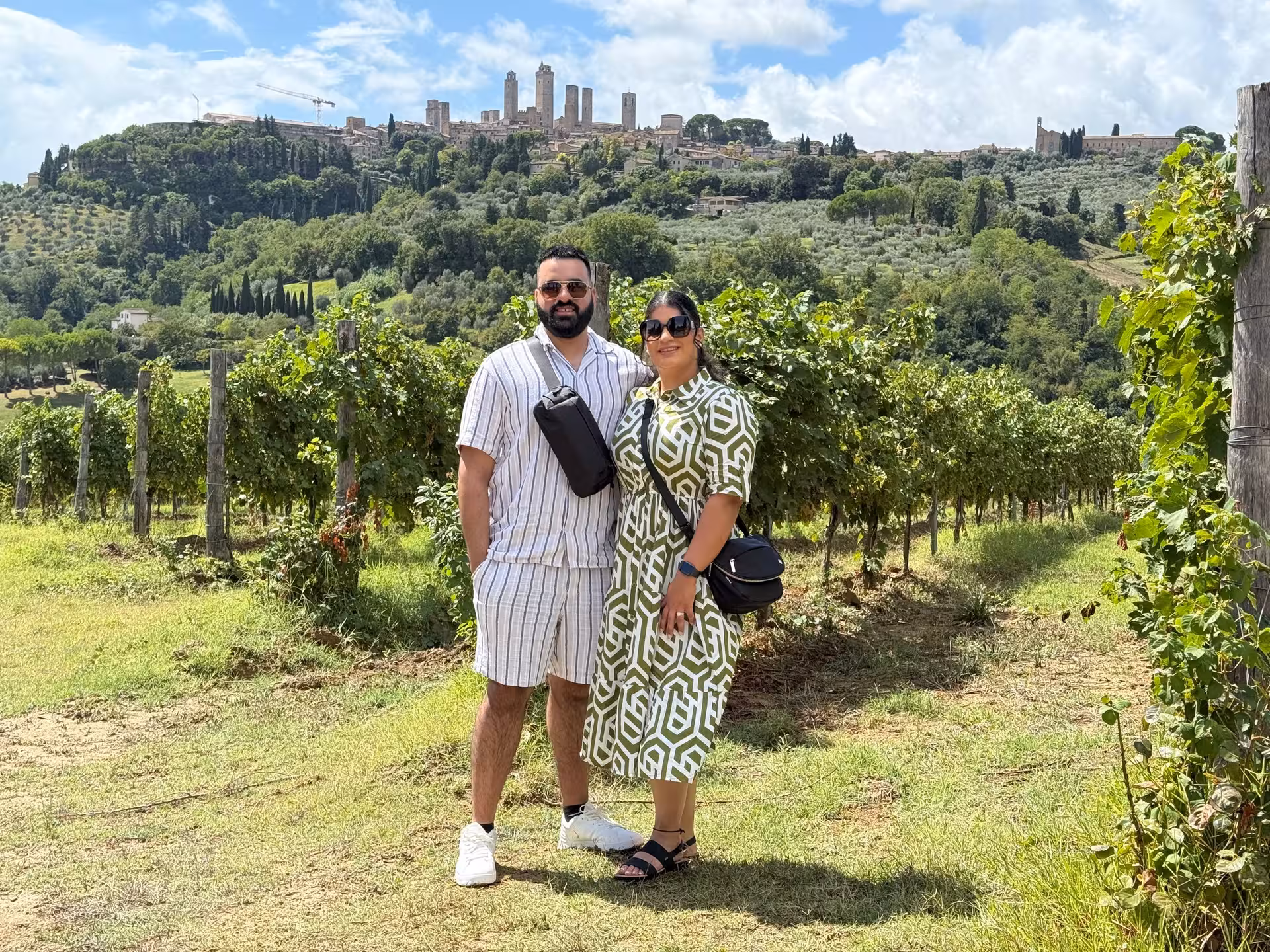 Visitors standing in a vineyard with scenic views of San Gimignano during a Tuscany day tour from Florence.