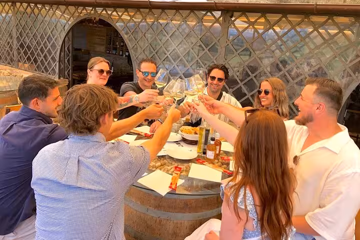 Group enjoying wine tasting at a Tuscan winery, showcasing camaraderie and authentic Chianti flavors.