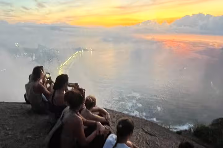 Tour group captures breathtaking sunset views overlooking the ocean from Two Brothers Mountain summit.