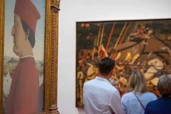Visitors on a guided tour admire Renaissance paintings in Florence’s Uffizi Gallery during a skip-the-line combo experience
