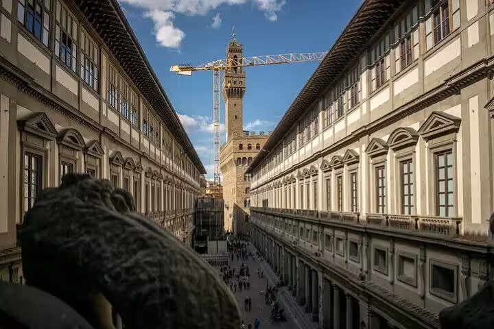 View along the Uffizi Gallery courtyard toward Palazzo Vecchio tower on a sunny day during a Florence skip-the-line guided tour