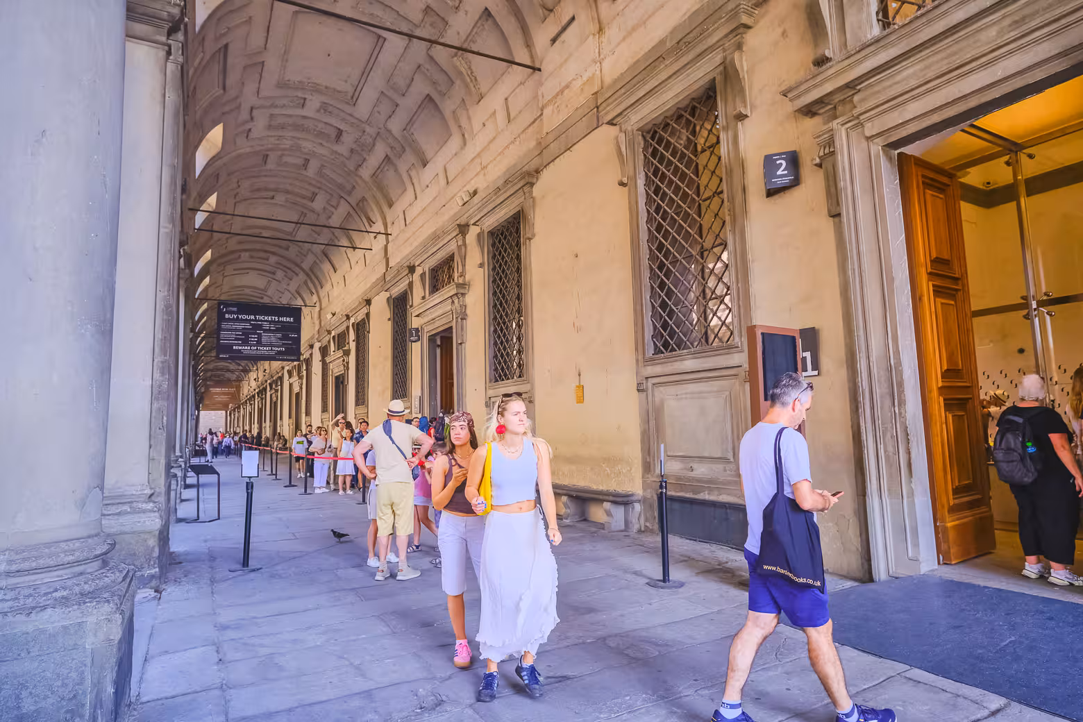 Visitors queue under the ornate arches at Uffizi Gallery entrance during the Best of Florence walking tour.