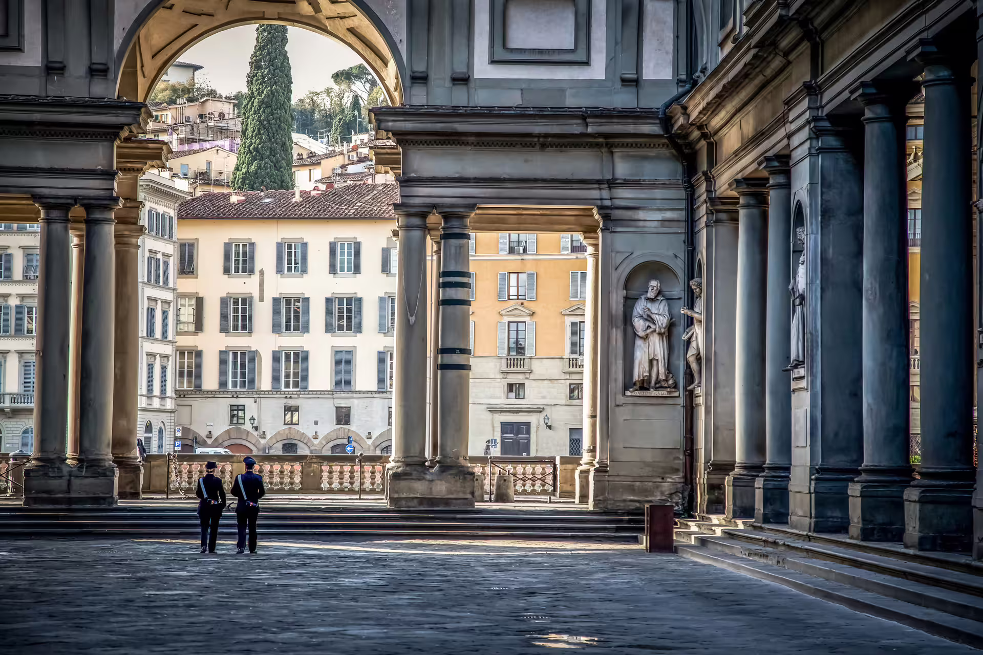 Strolling through the historic Uffizi Gallery courtyard in Florence on a full-day tour from Rome.