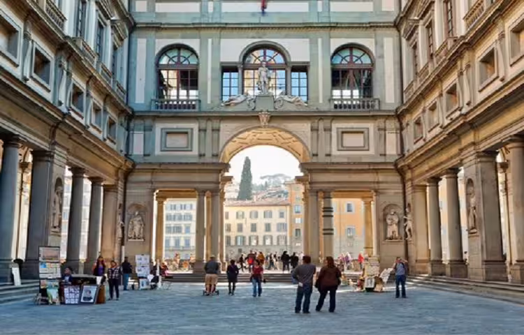 Tourists walk through the courtyard of the Uffizi Gallery in Florence during a semi-private day trip from Rome with lunch