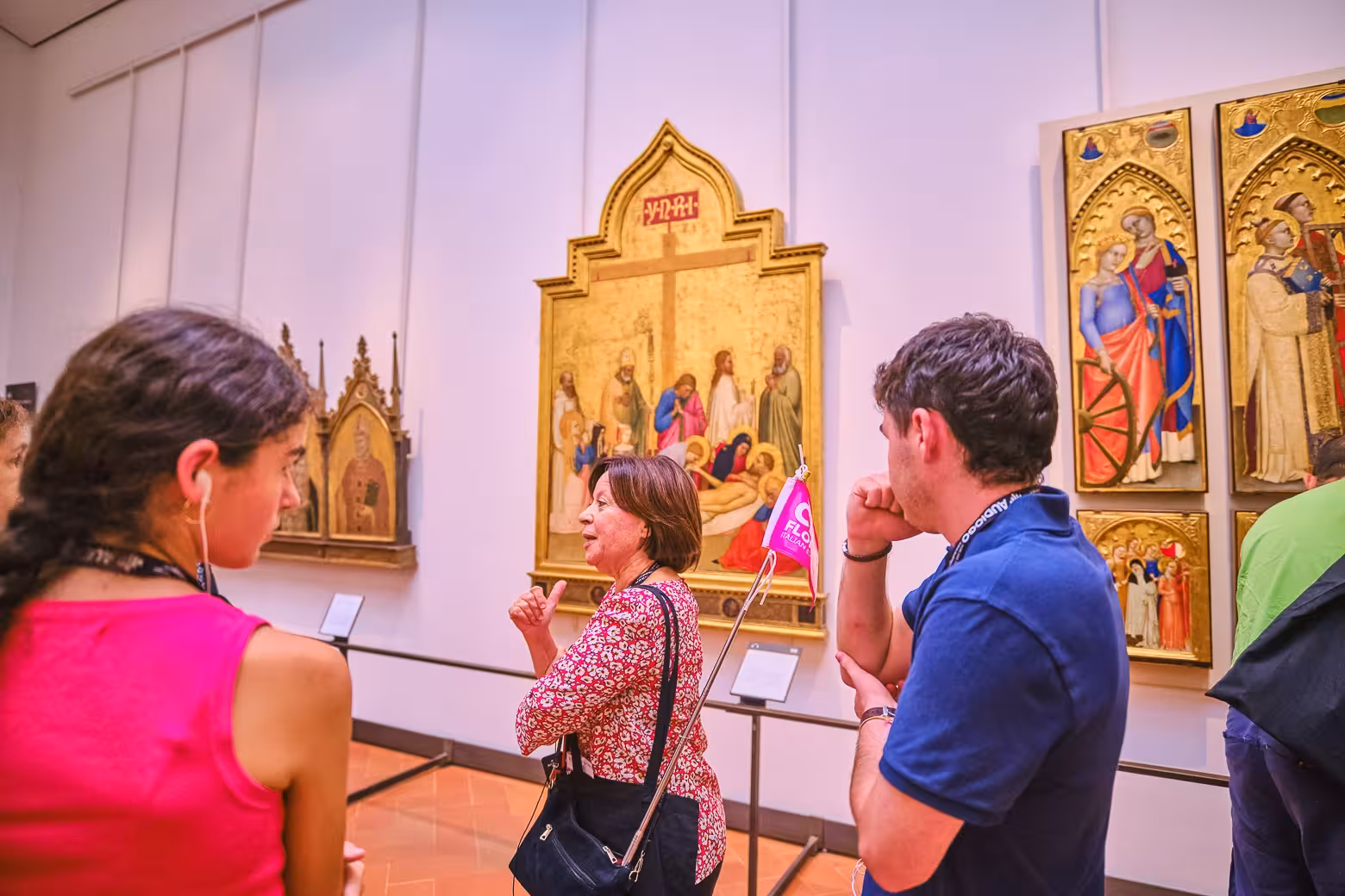 A tour guide explains historic paintings to guests at the Uffizi Gallery in Florence.
