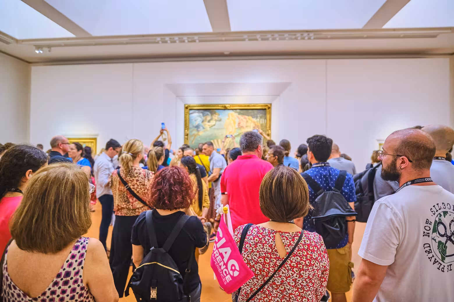 Visitors admire renowned artwork in a crowded Uffizi Gallery during a private tour with skip-the-line access.