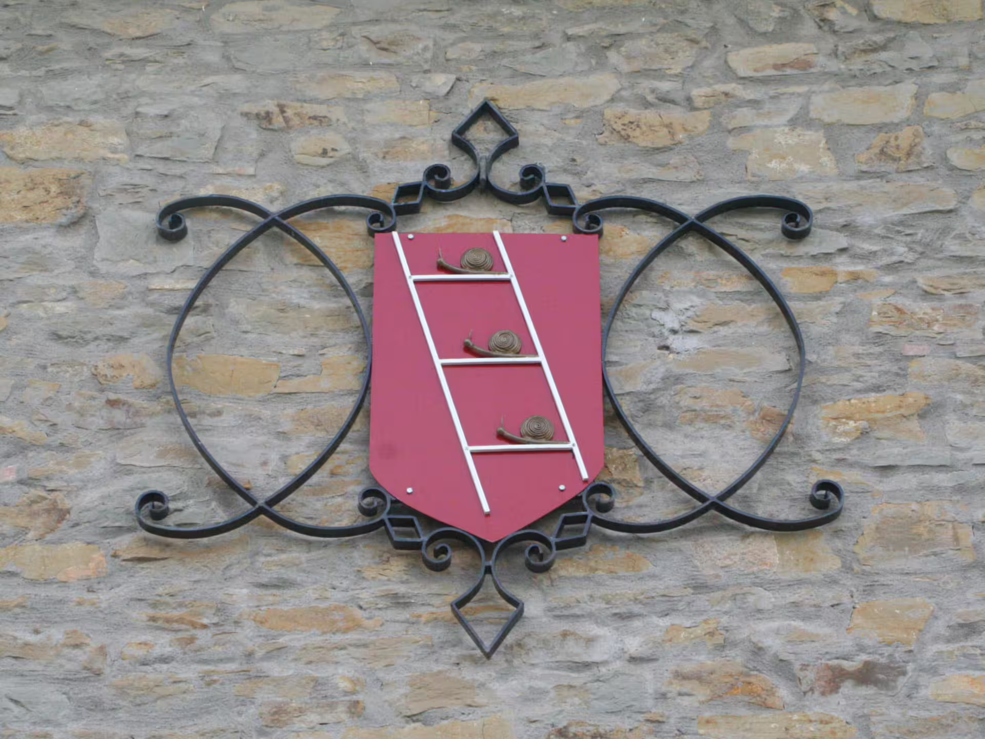 Winery crest on stone wall at Umbria estate, Perugia winery visit and tasting near Lake Trasimeno experience