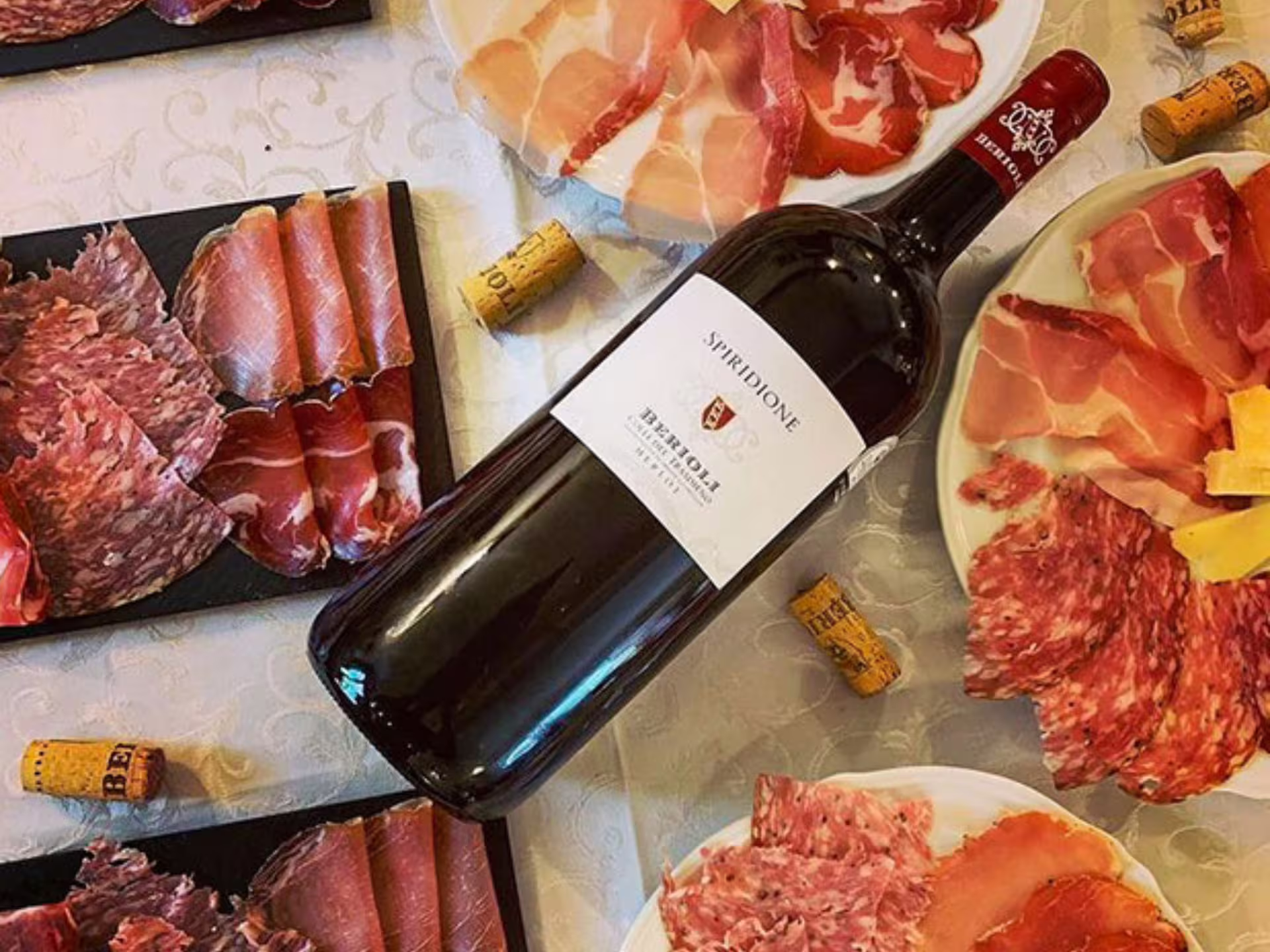 Umbrian red wine bottle with local salumi and cheese platter, Perugia winery tasting near Lake Trasimeno