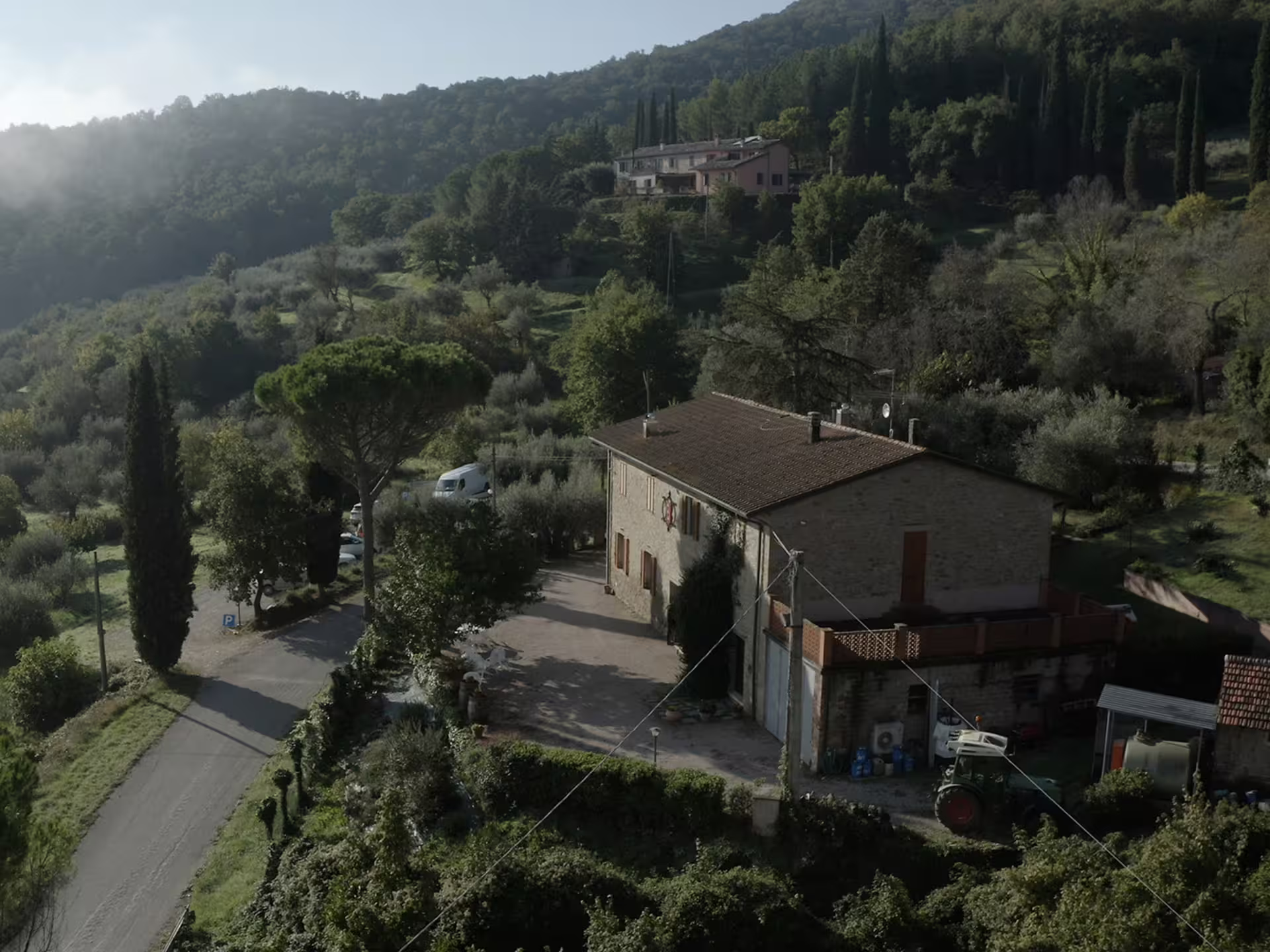 Umbrian farmhouse winery near Lake Trasimeno, Perugia, surrounded by olive groves and hills on wine tour