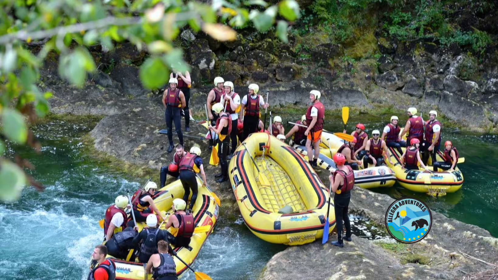 Guided Una River rafting from Plitvice Lakes, Croatia, with rafts and paddlers gearing up by rocky rapids