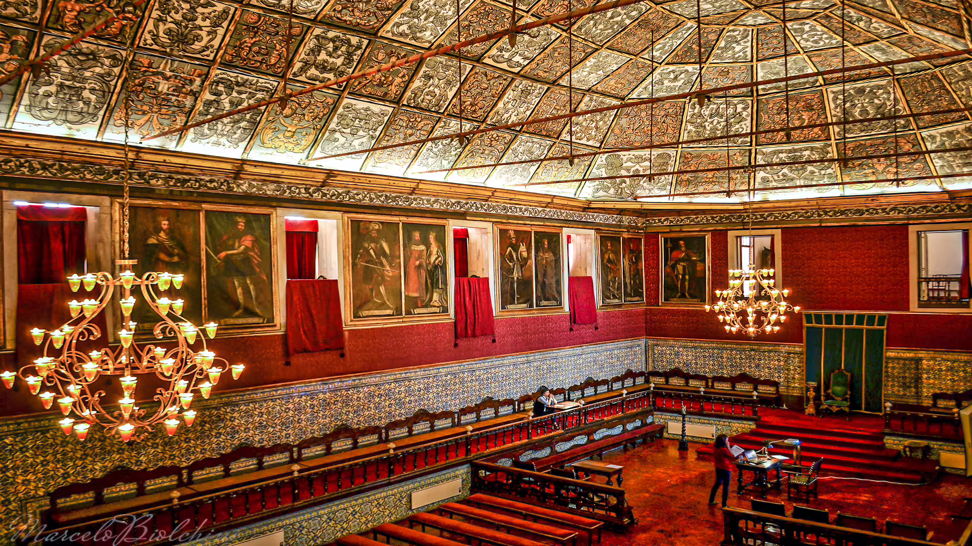 Elegant interior of University of Coimbra's historic hall with ornate chandeliers and detailed artwork, ideal for cultural tours.