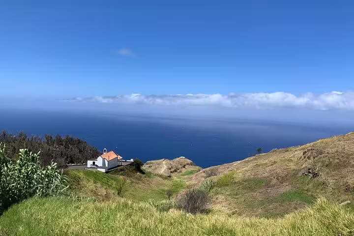 Breathtaking ocean view from a hilltop with a quaint building on The Untraveled West Tour.