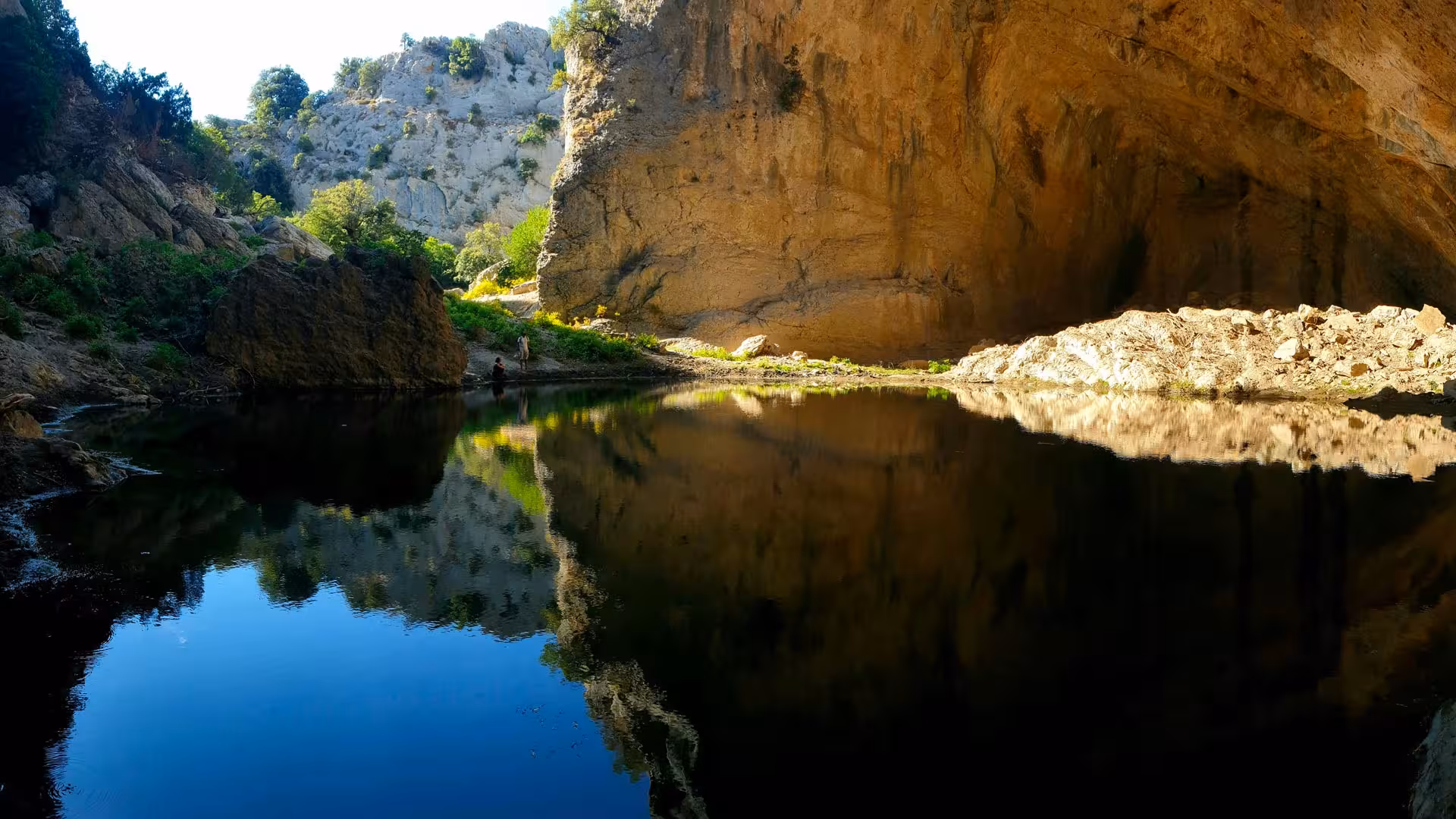 Scenic view of Supramonte cave with a tranquil lake, perfect for an Urzulei eBike tour adventure.