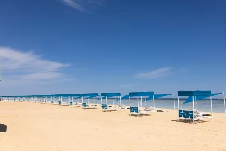 Utopia Bianca Island sandy beach with shaded loungers on the Red Sea, Hurghada day trip with lunch