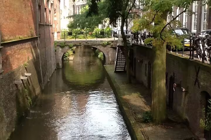 Hidden Utrecht canal with arched bridge and brick walls, ideal for “Your Own Utrecht” private tour