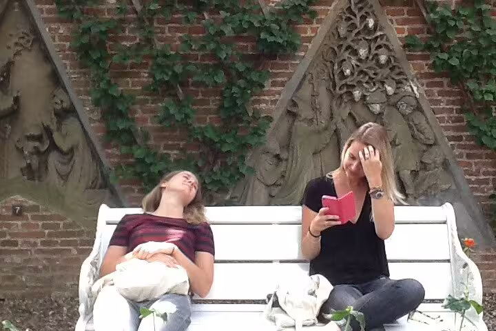 Travelers relaxing on a bench by medieval wall carvings in Utrecht, part of a private mysteries and treasures tour