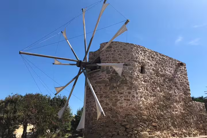 Historic windmill against a clear blue sky on the Palm Forest of Vai tour, highlighting traditional Cretan architecture.