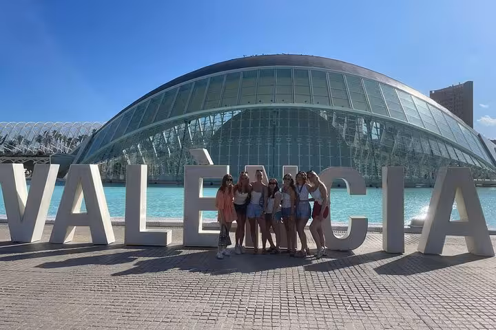 Valencia bike tour in Dutch group at City of Arts and Sciences, posing by Valencia sign and lagoon