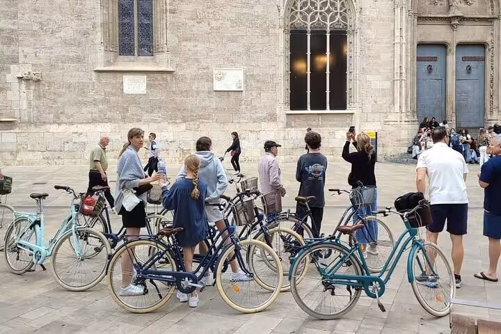 Dutch-guided Valencia bike tour group with city bikes in Plaza de la Virgen by the cathedral façade