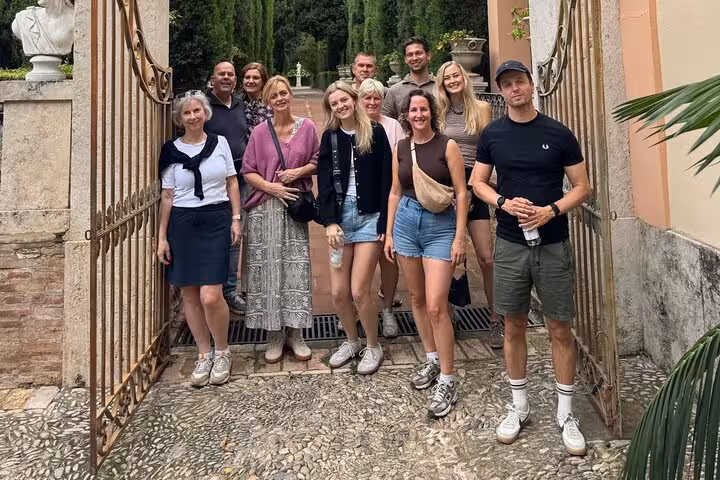 Participants on a Dutch Valencia bike tour posing at a garden gate, ready to explore city highlights