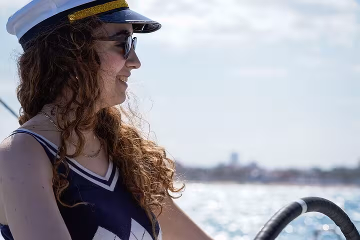 Smiling skipper at the helm on Valencia catamaran cruise, part of the e-bike tour and sea experience