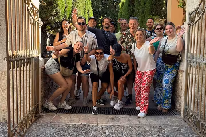 Smiling group on Valencia all-in-one e-bike tour, stopping in the old town streets between beach and city arts