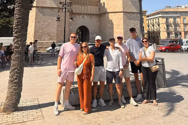 E-bike tour group photo in Valencia Old Town by Torres de Serranos, beach-to-arts city ride experience
