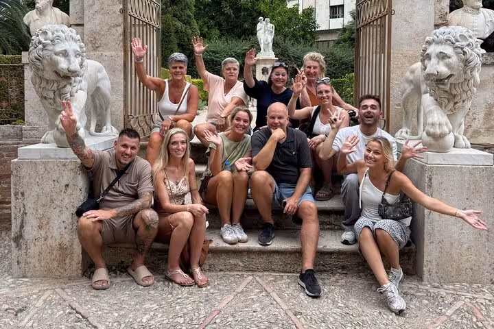 Happy group photo at Valencia old town stone gate on all-in-one e-bike tour of beaches and city arts