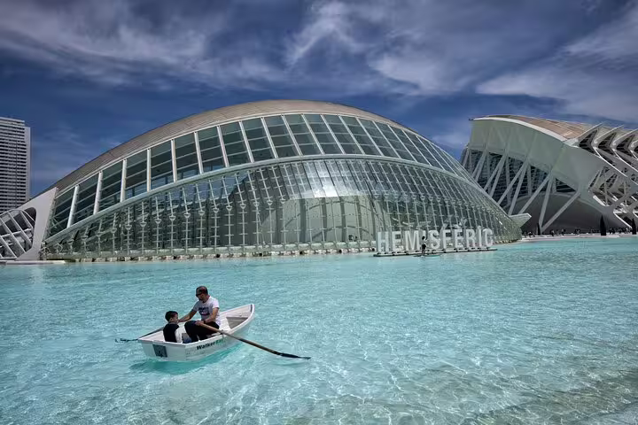 Family enjoying a boat ride at Valencia’s City of Arts and Sciences, showcasing modern architecture and crystal-clear waters.