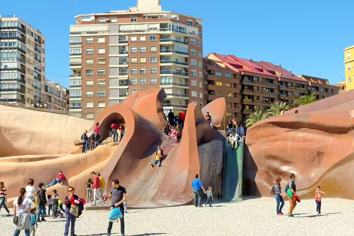 Families enjoy exploring the unique playground at Gulliver Park in Valencia, a highlight of the private family tour experience.