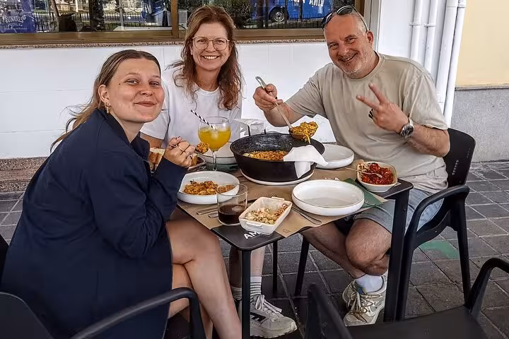 Guests enjoying paella and tapas at an outdoor Valencia stop on the gourmet tapas tour by bike or on foot