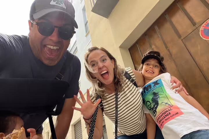 Happy family selfie on Valencia Iconic Sights scavenger hunt, exploring old town streets and clues