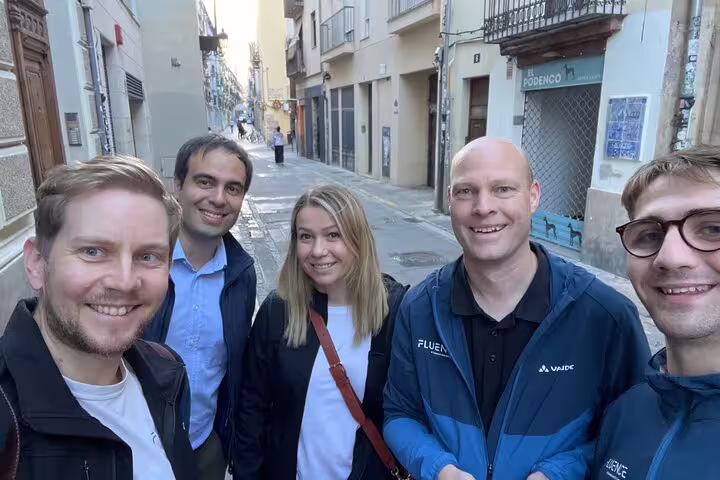 Friends smiling in Valencia old town during Iconic Sights scavenger hunt, team adventure walking tour