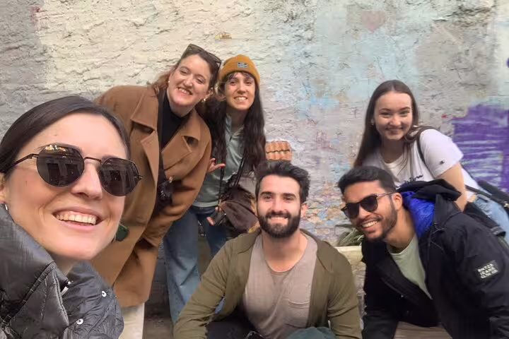 Friends posing on Valencia Iconic Sights scavenger hunt, smiling by colorful street art in El Carmen
