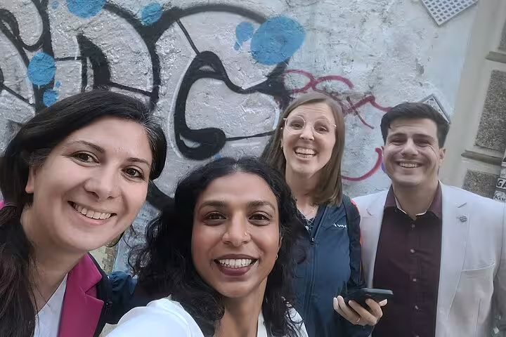 Group selfie by street art on Valencia Iconic Sights scavenger hunt, solving clues in the historic center