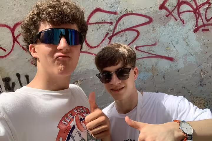 Two travelers give thumbs up on Valencia Iconic Sights scavenger hunt, selfie by graffiti wall