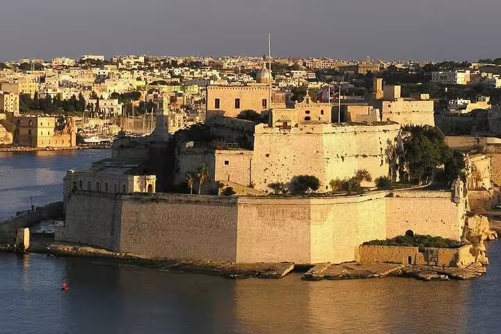Sunset view of Fort St. Angelo bathed in golden light, highlighting Valletta's historic charm on a Harbours Cruise tour.