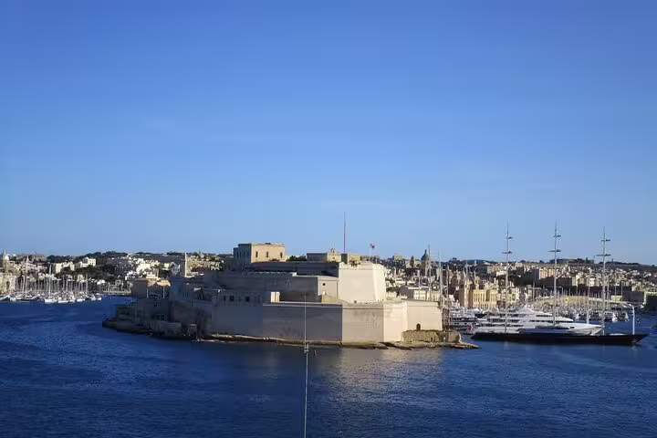 View of Fort St. Angelo from the sea during a sunny day on a Valletta Harbours Cruise, showcasing historic architecture and yachts.