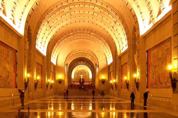 Golden-lit basilica nave inside Valley of the Fallen, included on El Escorial and private minivan day tour