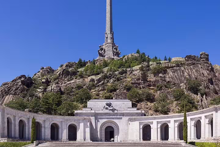 Entrance colonnade at Valley of the Fallen with towering cross, stop on Escorial private tour by minivan