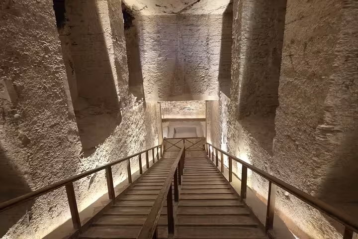 Wooden stairway descending into a Valley of the Kings tomb, part of a private Luxor day tour experience