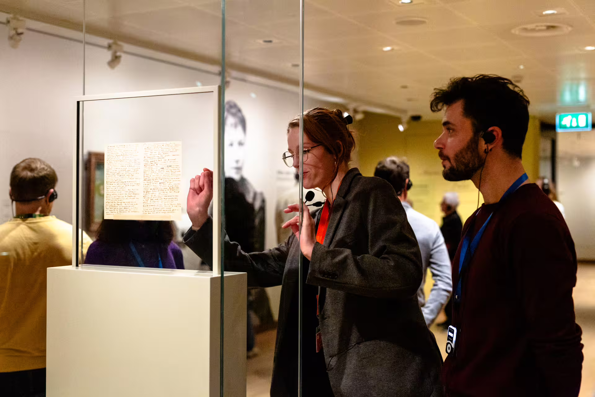 Visitors engage with Van Gogh's letters during a guided tour at the museum, wearing headsets for an immersive experience.
