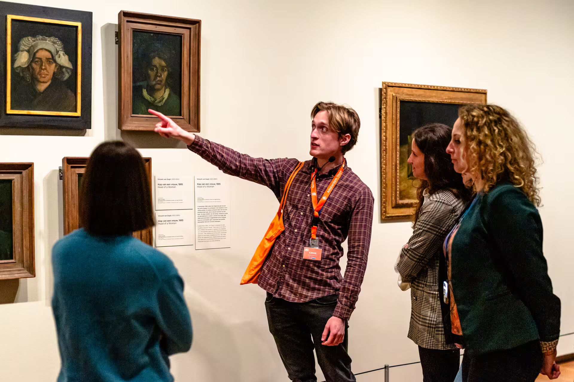 A museum guide leads visitors on a Van Gogh tour, explaining the artworks on display, perfect for art enthusiasts.