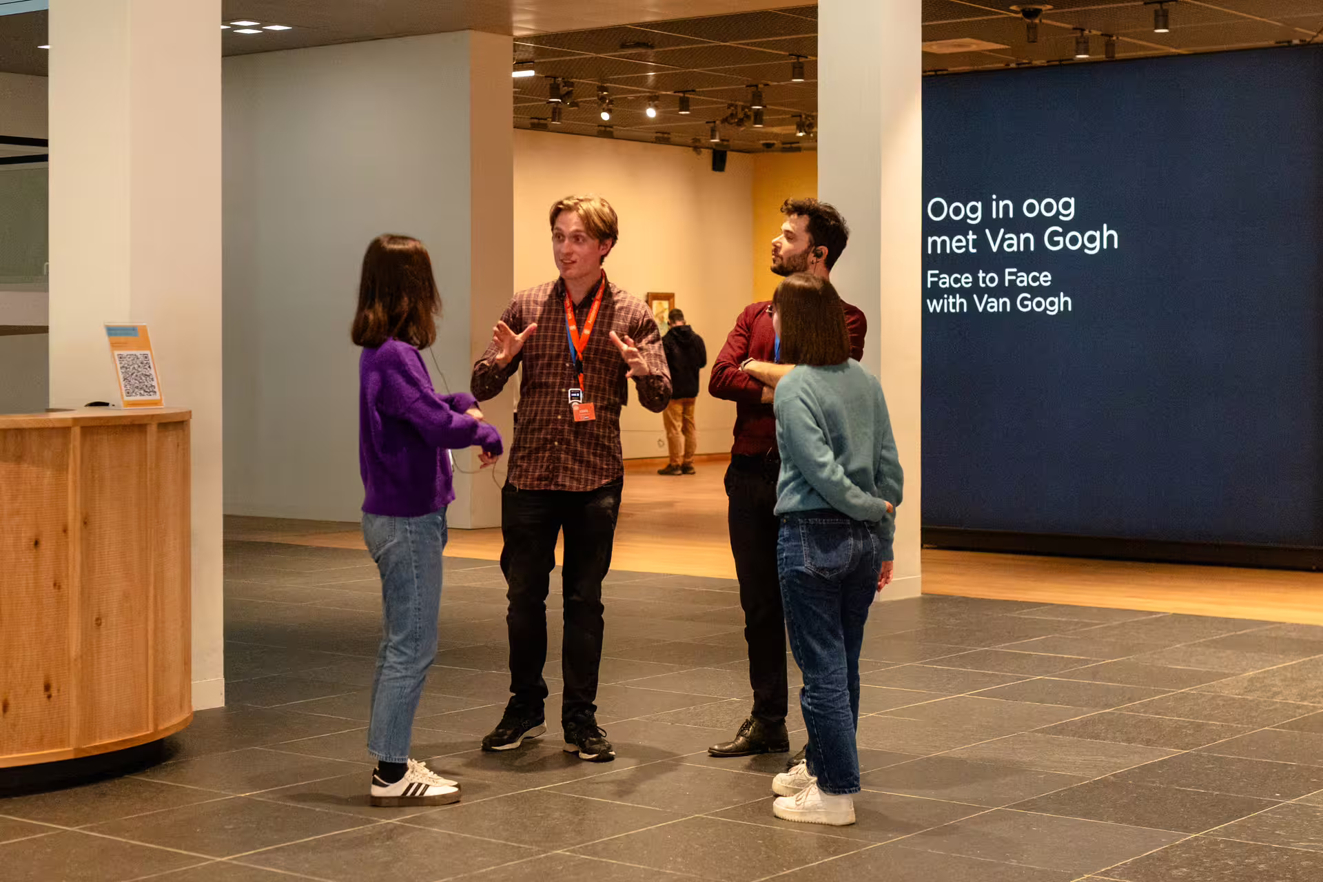 Visitors engage with a guide during a Van Gogh museum tour, exploring art insights and history in an interactive experience.