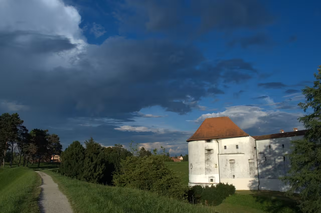 Varaždin Old Town fortress in Croatia, white tower and park path under dramatic skies on the day tour