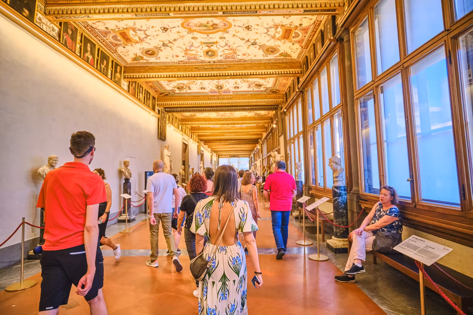 Visitors exploring the ornate Vasari Corridor on a private tour of the Uffizi Gallery in Florence.