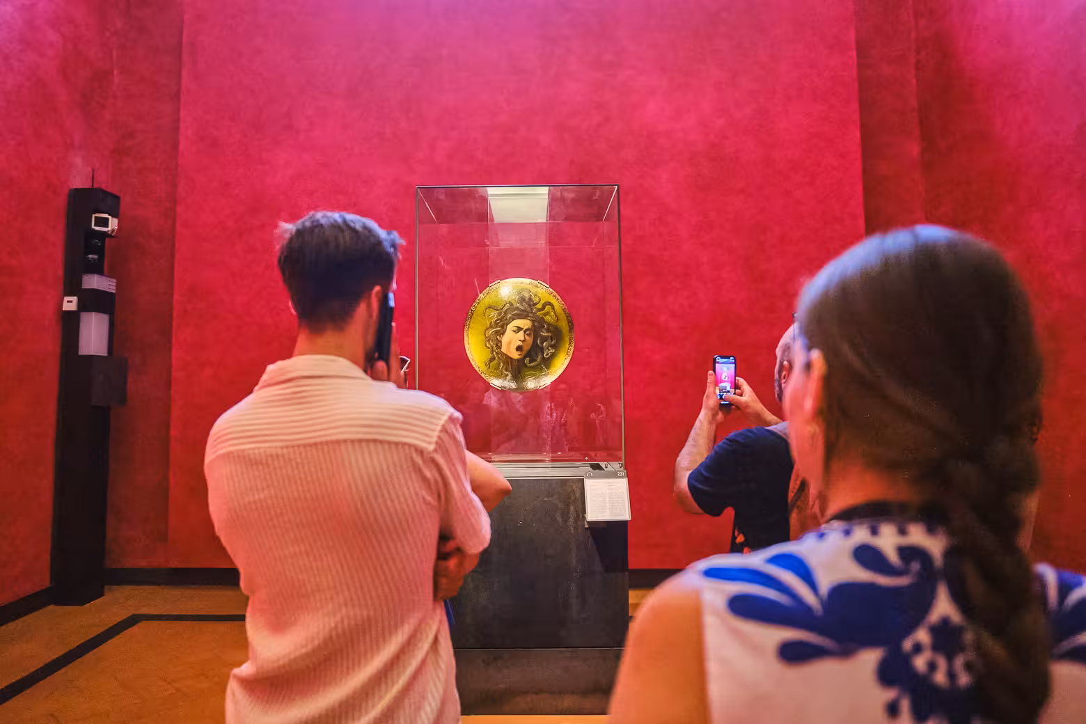 Visitors admire Medusa artwork in the Uffizi Gallery on a private Vasari Corridor tour in Florence.