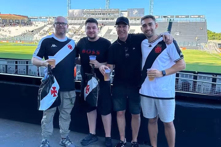 Local guide with Vasco da Gama supporters inside Rio de Janeiro stadium, pre-game beers and team jerseys