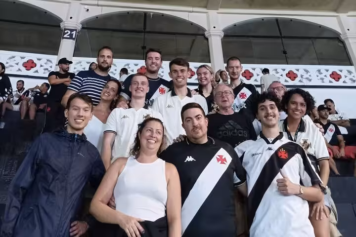 Tour group in Vasco da Gama jerseys posing in the stands at São Januário stadium, Rio matchday with guide