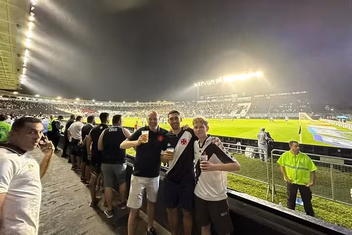 Vasco da Gama fans with local guide at night match in Rio de Janeiro stadium, drinks and pitch view